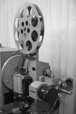 Vintage projektör açıldı. Lensten çıkan ışık. Ender endüstriyel sinema 35 mm film yazıcısı, klasik siyah beyaz, analog optik süreç, post-prodüksiyon fabrikasında rgb lambaları ve makaraları ile