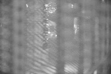 Arka plan olarak bulanık, bulanık, beyaz metalik ağ örülmüş, bulanık bir örümcek ağı var. beyaz ve siyah. 