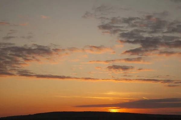 Bright big sun on the sky with clouds. Sun going down touching horizon line