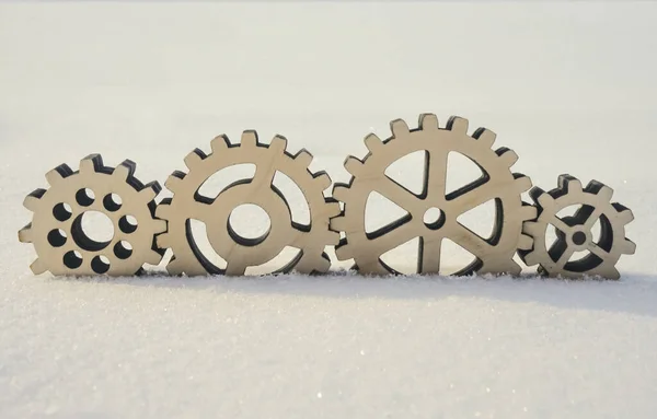 4 four wooden gear lie on snow background. idea of  winter studded wheels