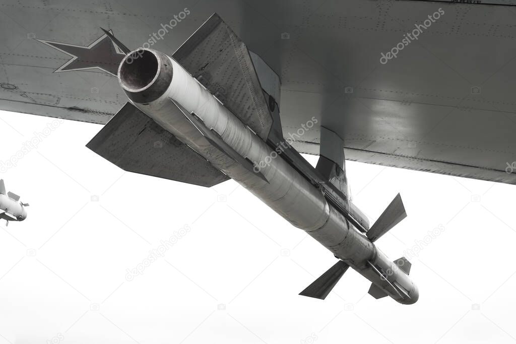 combat missile under the wing of the aircraft close-up. isolated on white background. concept of armed confrontation between different countries and defending their interests by force