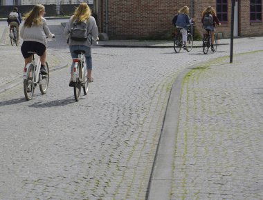  Avrupa caddesinde bisiklet süren kadınlar. Şehir bisikleti. Antwerp, Belçika.