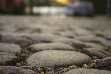 Yoldaki taşları parçalıyorlar. Kaldırım seviyesinden bak. Seçici odaklanma. Sokakta park etmiş Avrupa arabaları.