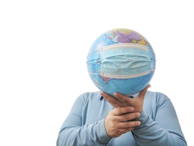 Dünya Salgın Tehlikesi. Dünya 'nın, beyaz bir arka planda izole edilmiş yüz maskesi ve elleriyle Dünya' yı korumaya ihtiyacı var. İnsan salgını tehlikesi. Erkek yüzünün arkasında virüs maskesi olan dünya haritası. 