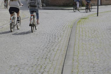  Avrupa caddesinde bisiklet süren kadınlar. Şehir bisikleti. Antwerp, Belçika.
