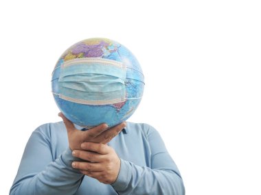 Dünya Salgın Tehlikesi. Dünya 'nın, beyaz bir arka planda izole edilmiş yüz maskesi ve elleriyle Dünya' yı korumaya ihtiyacı var. İnsan salgını tehlikesi. Erkek yüzünün arkasında virüs maskesi olan dünya haritası. 