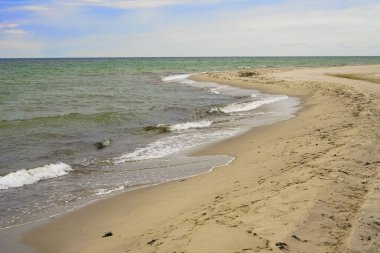 Kumlu, boş deniz kıyısı, deniz manzaralı. bulutlu mavi gökyüzü arkaplanı. 