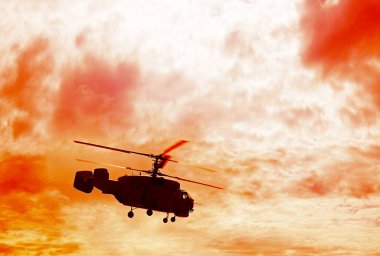 Yeşil çimlerin üzerinde uçan Rus askeri helikopterinin silueti. bulutlu gökyüzü.