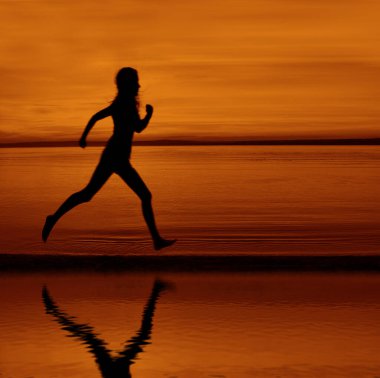 Gün batımı plajında yansımayla koşan kadın koşucunun silueti. Gün batımında deniz sahilinde koşan küçük bir kız figürü. Dişi güneş doğarken okyanus kıyısında koşuyor. Dışarıda egzersiz yapıyorum. Doğada sağlıklı aktif çalışma yaşam tarzı
