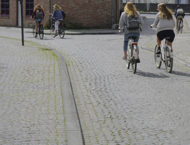  Avrupa caddesinde bisiklet süren kadınlar. Şehir bisikleti. Antwerp, Belçika.