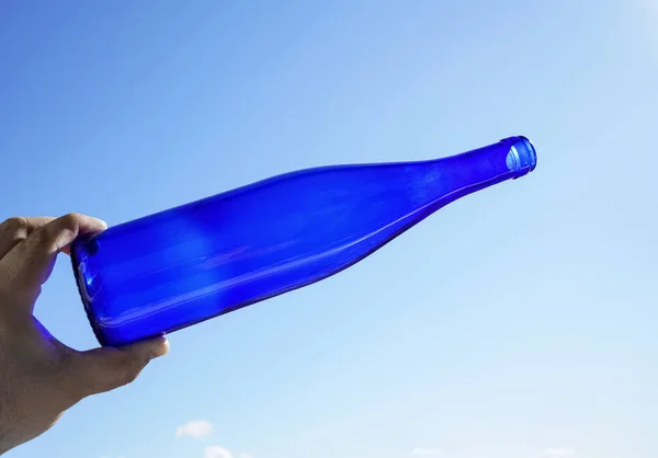 Человек Держит Бутылку Вина Солнечном Голубом Фоне Неба — стоковое фото