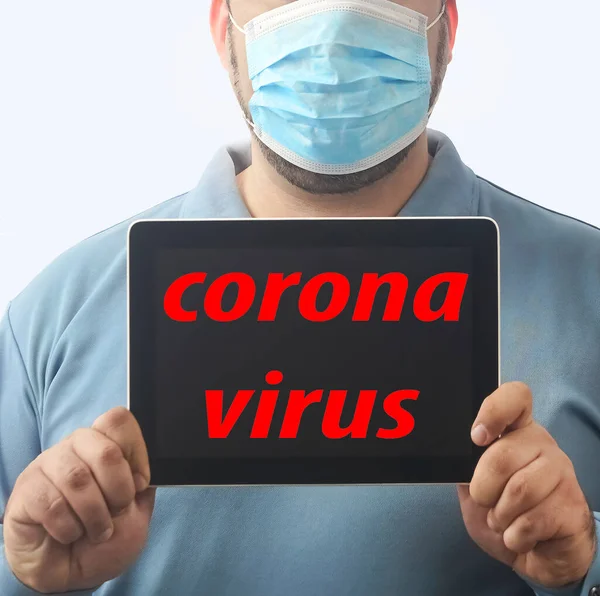 Man with mask to protect him from Coronavirus. Corona virus pandemic. Man hold  mask before face. Young man with mask standing. Person in hood with medical mask. isolated on white background. tablet computer in hands. inscription on screen.