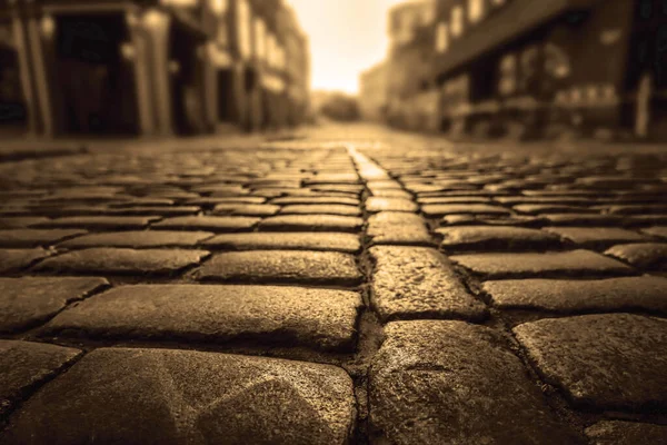 Old town in Europe at sunset with retro vintage cobble stone. cobble paving Stones background for walking.