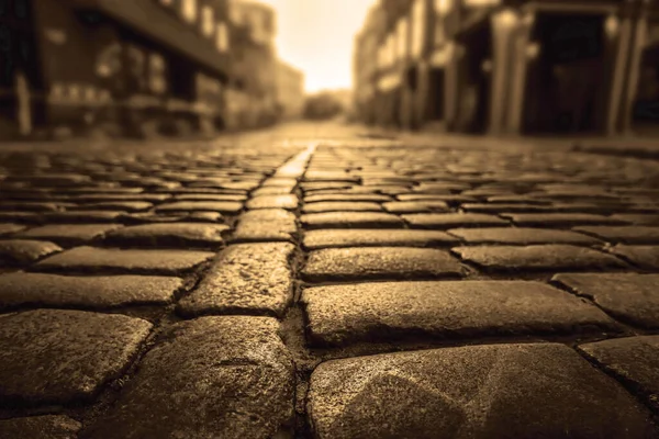 レトロなヴィンテージの石畳で日没時にヨーロッパの旧市街 石畳の道を歩く石の背景 — ストック写真