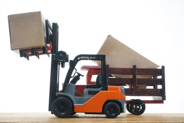 Forklift kargoyu depodan kamyona yüklüyor. Beyaz arka planda izole edilmiş. Karton kargo kutuları beyaz üzerine izole edilmiş standart küçük motor kamyon kaldırma