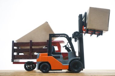 Forklift kargoyu depodan kamyona yüklüyor. Beyaz arka planda izole edilmiş. Karton kargo kutuları beyaz üzerine izole edilmiş standart küçük motor kamyon kaldırma
