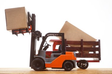 Forklift kargoyu depodan kamyona yüklüyor. Beyaz arka planda izole edilmiş. Karton kargo kutuları beyaz üzerine izole edilmiş standart küçük motor kamyon kaldırma