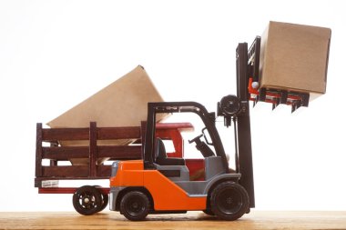 Forklift kargoyu depodan kamyona yüklüyor. Beyaz arka planda izole edilmiş. Karton kargo kutuları beyaz üzerine izole edilmiş standart küçük motor kamyon kaldırma