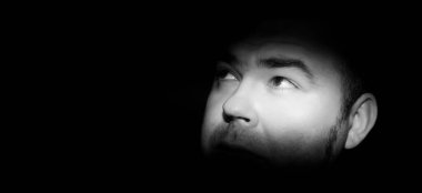 Korku için kahverengi gözlü bir adamın portresi. Yüzünde ve gözlerinde dar bir ışık şeridi var. Alacakaranlıkta kabus 