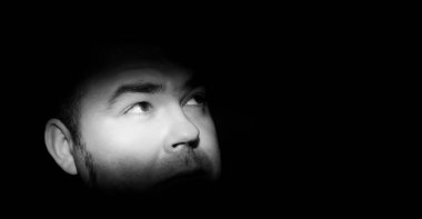 Korku için kahverengi gözlü bir adamın portresi. Yüzünde ve gözlerinde dar bir ışık şeridi var. Alacakaranlıkta kabus 