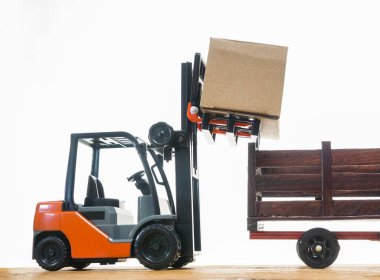 Forklift kargoyu depodan kamyona yüklüyor. Beyaz arka planda izole edilmiş. Karton kargo kutuları beyaz üzerine izole edilmiş standart küçük motor kamyon kaldırma