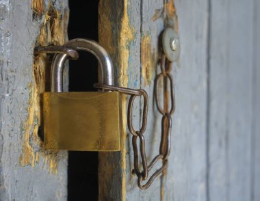 Kapıda eski demir kilit asılı. Kilitli, asma kilitli, ahşap bir kapı.