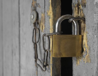 Kapıda eski demir kilit asılı. Kilitli, asma kilitli, ahşap bir kapı.