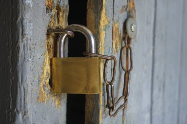 Kapıda eski demir kilit asılı. Kilitli, asma kilitli, ahşap bir kapı.