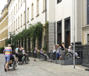 Engelli erkek ve kadınlardan oluşan bir grup, kentin caddesinde tekerlekli sandalyelerini sürüyorlar.. 