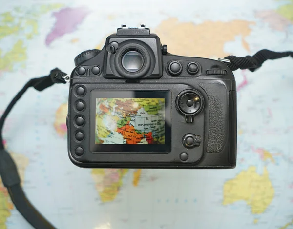 世界地图在屏幕专业摄影相机上的图像 顶部视图 旅行生活概念 — 图库照片