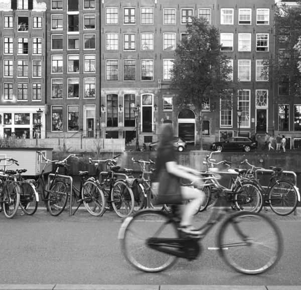 荷兰阿姆斯特丹市一名身穿绿色长裙 提包骑自行车的年轻女子出现在人们面前 — 图库照片