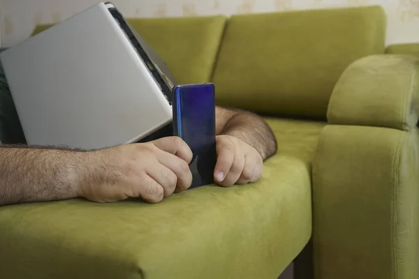 工作努力的中年人坐在绿色的沙发上一边读书一边聊天 笔记本电脑在头顶上方 — 图库照片