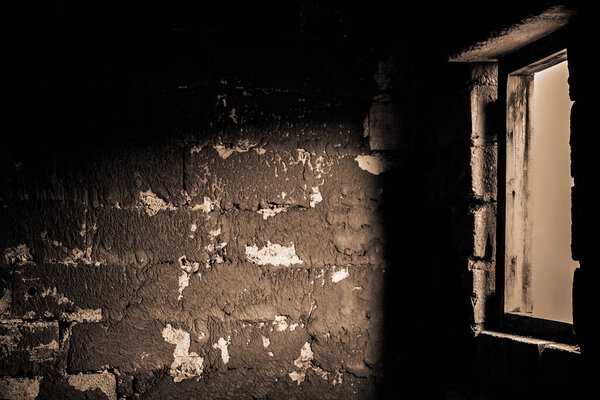 A wall of aerated concrete blocks in a building under construction with the projection of light from a window on the wall. Background of construction stages of the house walls, texture of white bricks