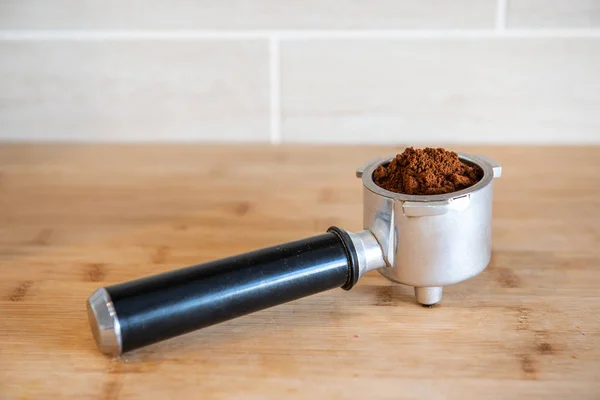 Suporte de filtro com café moído em mesa de madeira — Fotografia de Stock