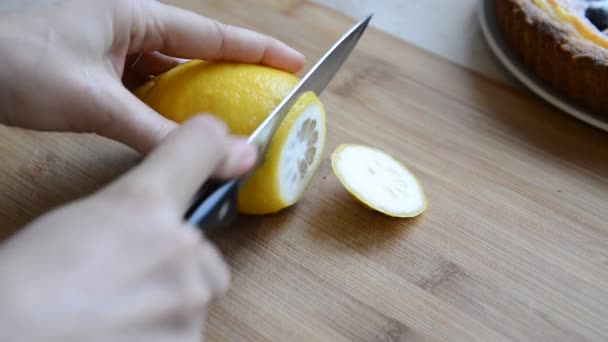 Женщина резала лимон на доске ножом — стоковое видео