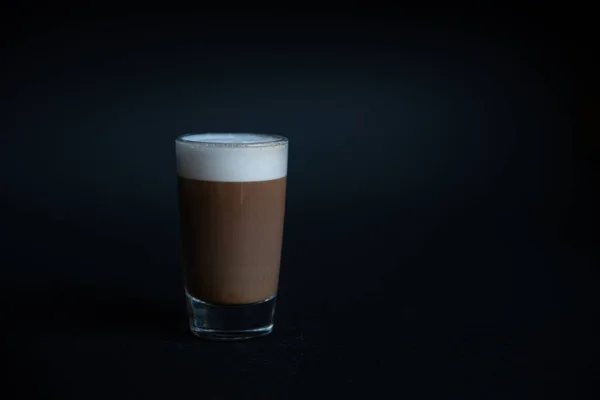 Mini kopje cappuccino in een glazen beker op zwarte achtergrond — Stockfoto