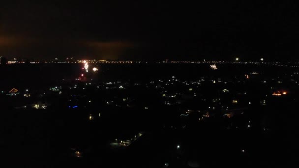 Przegląd lotniczy nocnego miasta podczas noworocznych fajerwerków. Pożar ciężarówki z migającymi światłami na miasto idzie do ognia — Wideo stockowe