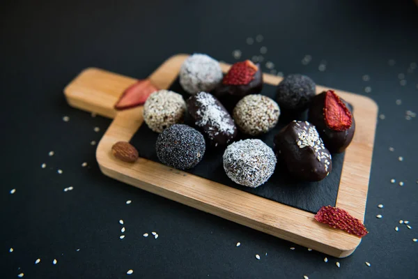 Set di caramelle di frutta e cioccolato fatte a mano su una tavola di legno Immagine Stock