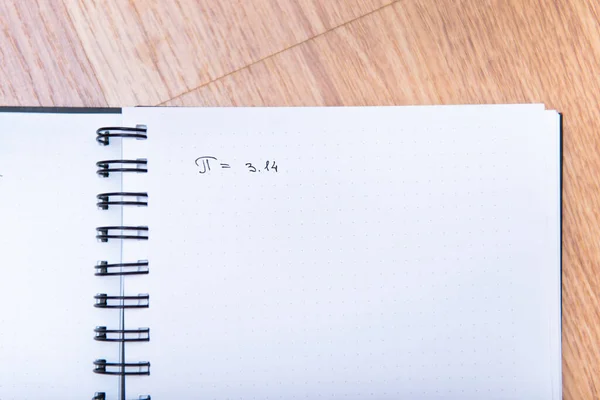 Число pi записується в блокноті з ручкою. Концепція числа на день Пі. Пі дорівнює 3.14 — стокове фото
