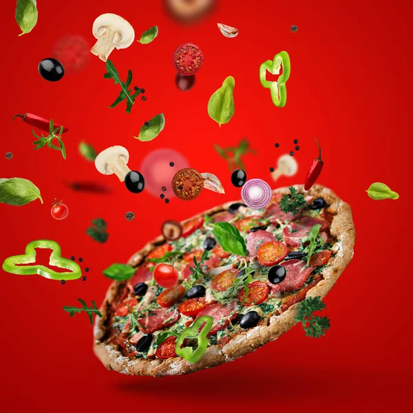 Flying pizza with ingredients colorful background vegetables meat basil oregano olive hot