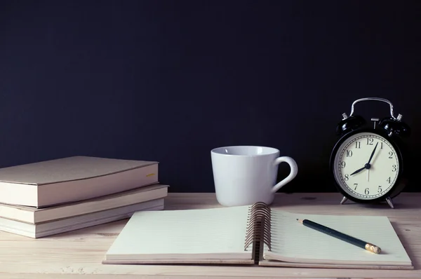 Ретрофільтр, блокнот з олівцем, ретро-годинник, чашка кави та книги на столі . — стокове фото