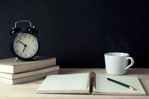 Arbeitsplatz mit Uhr für Bücher, Notizbuch, Bleistift und Kaffee auf dem Tisch. — Stockfoto