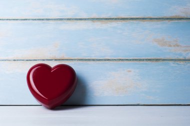 Kırmızı kalp yaslanmış gök mavisi ahşap tahta. Sevgililer kavramı.