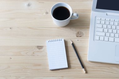 Defter, kalem, dizüstü bilgisayar ve ahşap masa kahve.