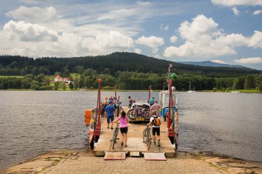 Lipno, Çek Cumhuriyeti-Ağustos 4, 2016: turistler ve bisikletçiler ile göl genelinde küçük feribot Lipno, Sumava, Güney Bohemia, 200 km güneyinde Prag kendi yaz aktivitelerini zevk