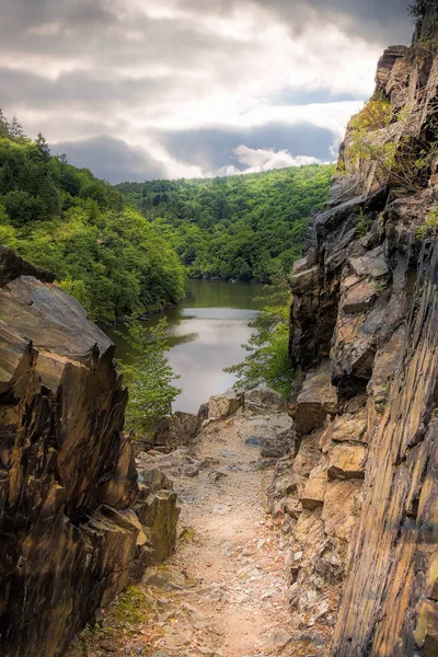 Landscape with country pathway through rocks along a river, dramatic light, Czech Republic near Prague, river Vltava.