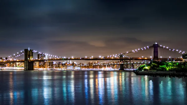 Brooklyn Bridge e Manhattans skyline à noite — Fotografia de Stock