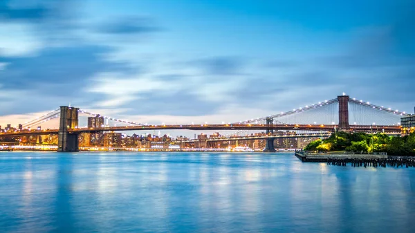 Brooklyn Köprüsü ve Manhattan siluetinin alacakaranlıkta — Stok fotoğraf