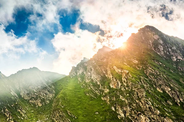Solen flare spricker bakom en bergstopp — Stockfoto