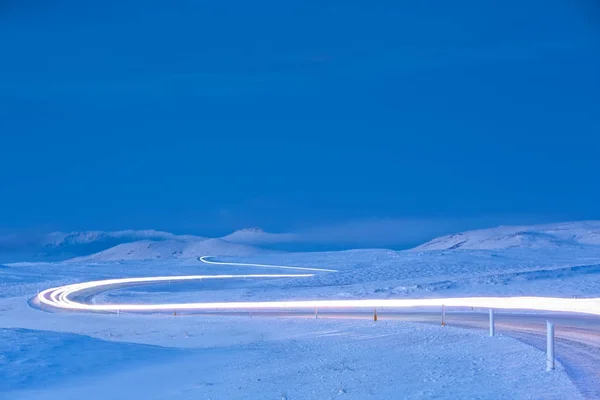 Amanhecer Uma Estrada Icelandic Enrolamento Coberto Neve Com Faróis Trilhas — Fotografia de Stock